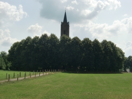 Bedburg-Hau : Louisendorf, die Ansicht zeigt die von Bäumen umgebene ev. Elisabethkirche. Im Sommer ist nur der Kirchturm zu sehen.